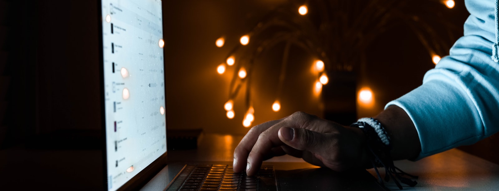 Business owner typing on a glowing laptop late at night, checking answers about their company